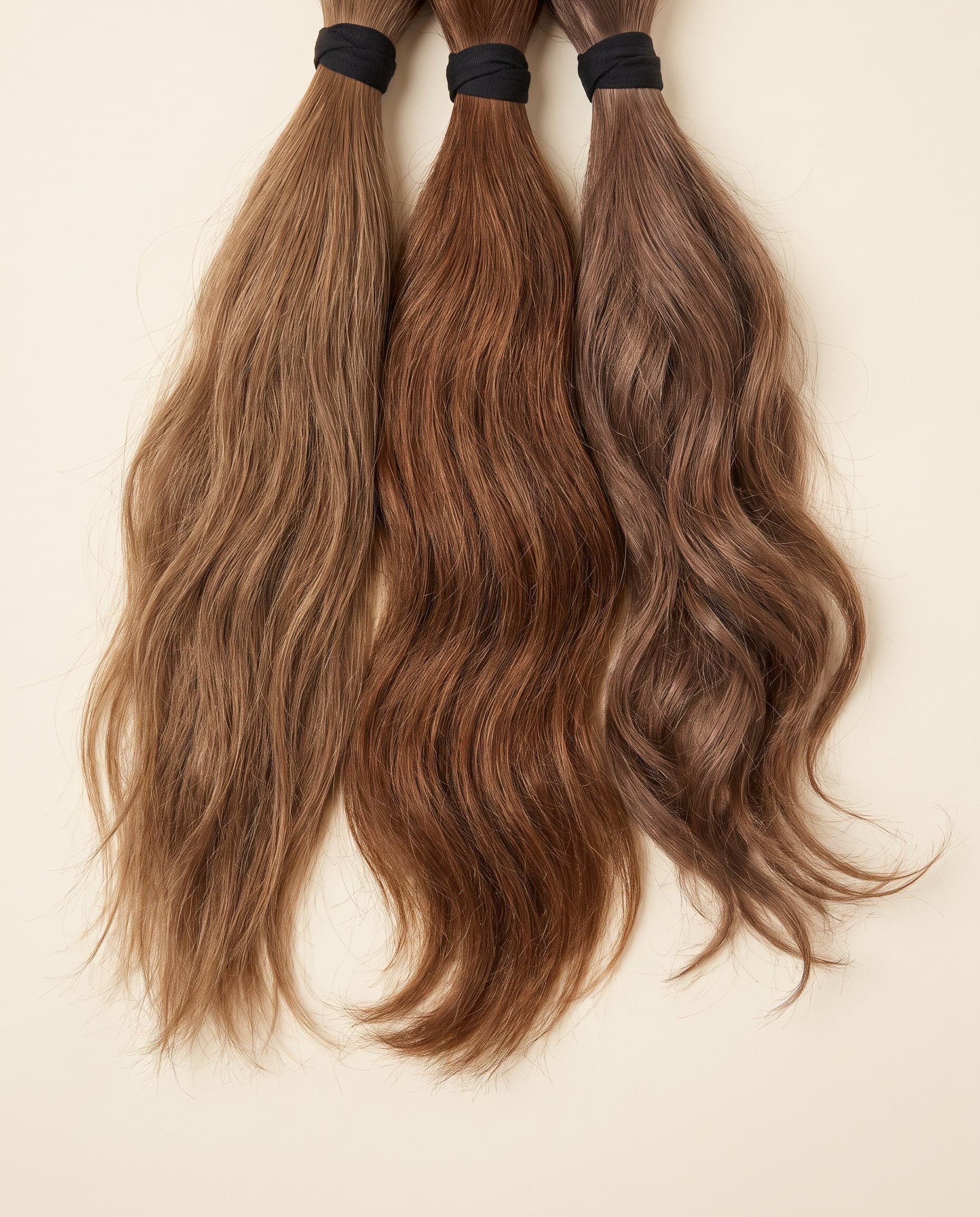 Fan of Gold grade single-donor hair bundles in natural light brown with black wraps